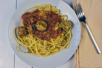 fettuccine top with sauce and chicken meatball