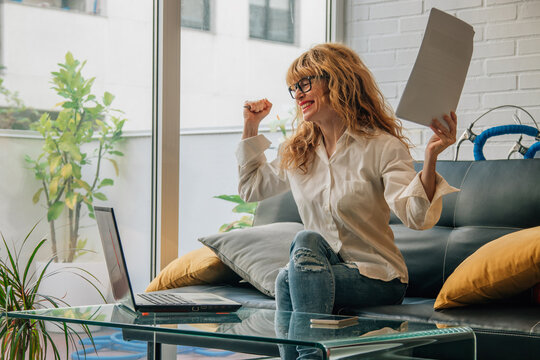 woman at home with computer and happy winning expression