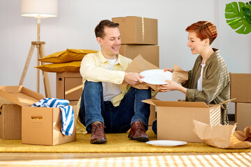 Excited young married couple buyers open unpack cardboard parcel box shopping online from home