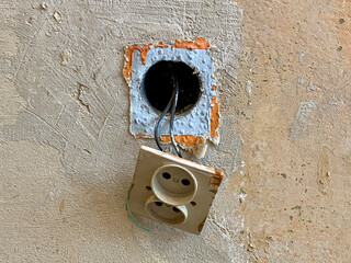 stary kontakt elektryczny i stara zniszczona ściana