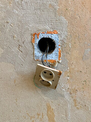 stary kontakt elektryczny i stara zniszczona ściana