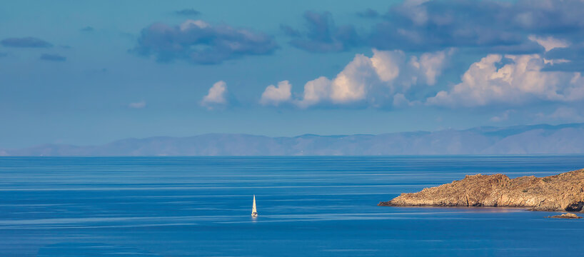 Sailboat. Isolated. Copy Space. Single white sailboat sailing  in the mediterranean travelling towards Zia island in Greece. Stock Image.