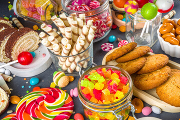 Selection of colorful sweets. Set of various candies, chocolates, donuts, cookies, lollipops, ice cream top view on black concrete background
