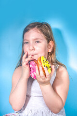 Little happy funny girl with colorful sugar glazed pink and yellow donuts, Holiday, happiness, summer vacation concept,