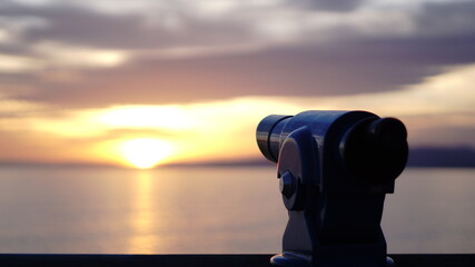 coin operated monocle against sunset