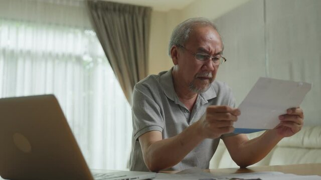 Asian senior man feeling stressed from financial problem and debt.