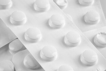White pills in white blister on white background