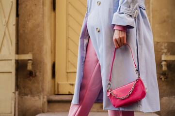 Street style, fashion details: small pink faux patent leather baguette bag in trendy outfit. Woman...