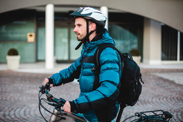 Young man with backpack and bicycle protective helmet.