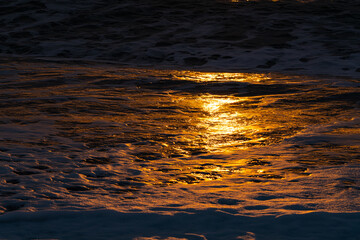 sea ​​foam during an orange sunset