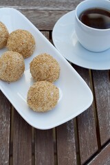 Sesame seed balls or Onde-onde. Indonesian traditional street food. glutinous rice flour stuffed with mung bean paste coated with sesame seeds. Served with a cup of coffee
