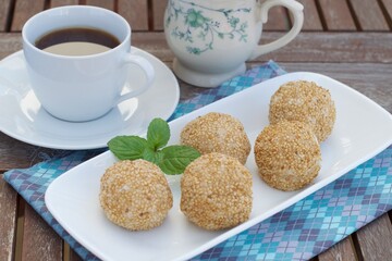 Sesame seed balls or Onde-onde. Indonesian traditional street food. glutinous rice flour stuffed with mung bean paste coated with sesame seeds. Served with a cup of coffee