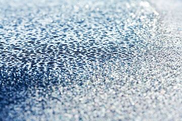 half frozen water droplets shot longitudinally onto a blue surface