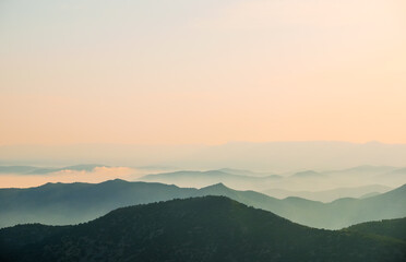 Sunset in the mountains. Layered mountains. Haze at sunset.
