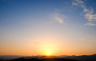 Sunset in the mountains. Layered mountains. Haze at sunset.