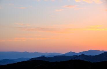 Sunset in the mountains. Layered mountains. Haze at sunset.