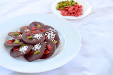 Homemade round chocolate bark with pistachio, coconut and goji berry