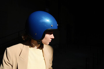 Biker pretty woman posing with blue retro helmet. Vertical.