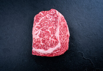 Raw dry aged wagyu cutlet steak cut offered as top view on black background with copy space