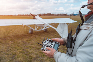 close up pilot hand with remote control joystick for agricultural spraying plane © goami