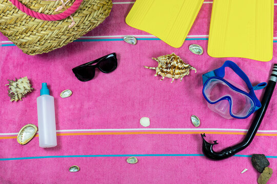 Toalla de playa con gafas de sol, gafas de bucear, aletas de bucear y conchas