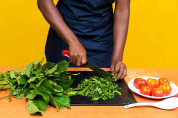 female black chef slicing vegetables, focus on hands
