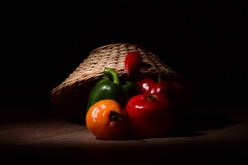 vegetables in a basket with wooden base and black background
