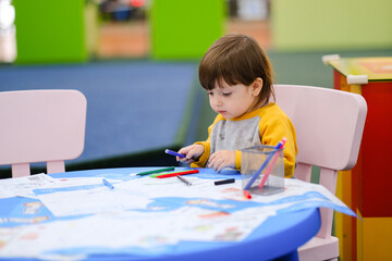 Creative baby development. Baby learns to draw. Early development of children in the Children's Development Center. Happy kid draws.