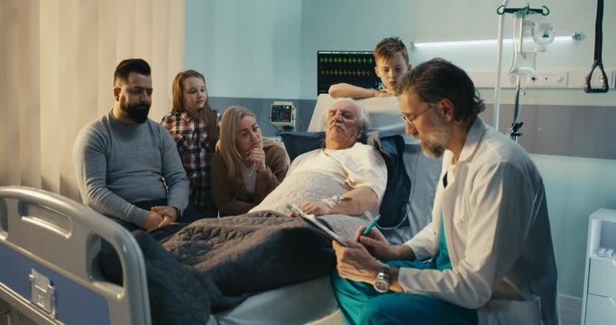Middle aged doctor speaking with family and patient and making notes