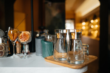 Four glass cups on the bar counter with serving accessories.