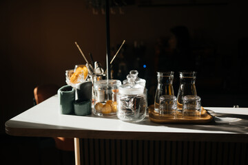 Four glass cups on the bar counter with serving accessories.