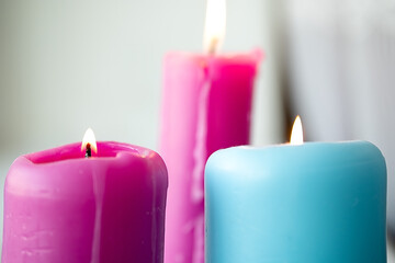 three thick candles stand on the windowsill, a fire is burning, horizontal.