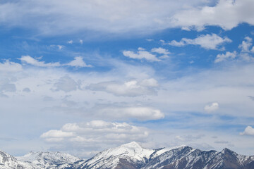 Mixed altocumulus clouds over snowy mountain - obrazy, fototapety, plakaty