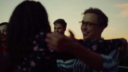 Friends hugging while meeting at party. People giving high five each other.