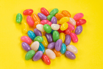 Several Jelly Beans over yellow background.