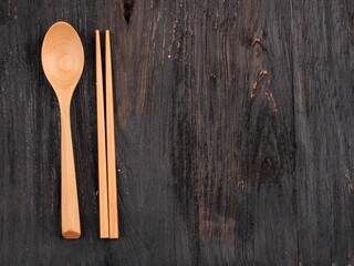 Spoon and Chopstick Wooden Cutlery on Rustic Black Wooden Table, Copy Space, Eat Concept  