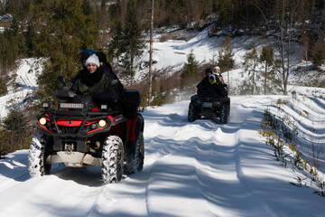 A group of young people ride ATVs in the snow-capped mountains. Carpathians. Ukraine.
