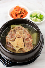 Gori Gomtang (Sokkori Gomtang) or Korean Beef Oxtail Stew  Soup, Served in the Black Korean Bowl with Kimchi and Sliced Green Onion