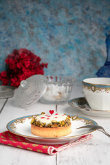 Small pie in an old plate with a cup of tea