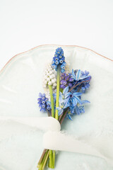 Beautiful fresh muscari grape hyacinth flowers wrapped in ribbon on a plate