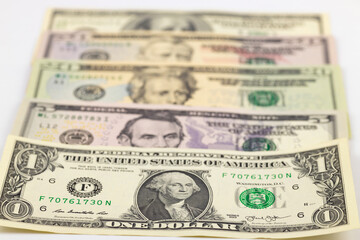 American dollars from one to one hundred lie on a white background. Close-up, selective focus. 