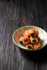 Pineapple Tart Roll Cookies (Tart Nanas) on Dark Background. Copy Space for Text or Recipe