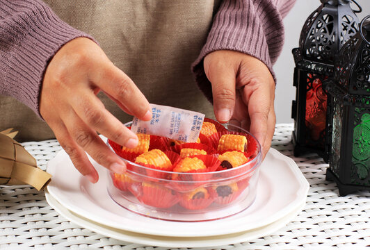 Asian Female Hand Put Silica Gel Pack to the Nastar Cookies Container Jar  to Absorp Moisture. Make the Cookies in Always Crispy and Delicious at the Store