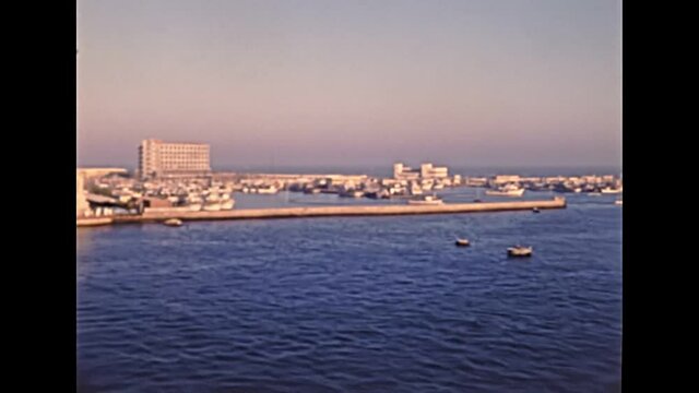 Port Said cityscape in Egypt from boat in Mediterranean sea. Historical archival of Egypt in 1980s with city lighthouse. Historical archival of Egypt in 1987.