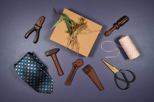 Father's Day Or Masculine Birthday Theme Flatlay Background Styled With Gift, Chocolate Tool Set And Tie. Blog Hero Header Creative Composition.