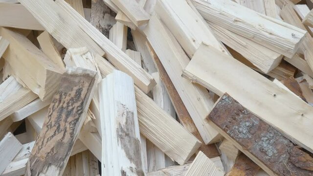 A heap of the cut firewoods on the ground from the cut logs