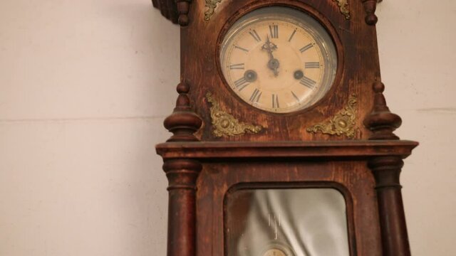 Broken antique mechanical wall clock that once showed the hour in room. Time