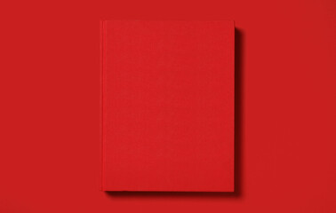 Hardcover book on red background, top view. Space for text