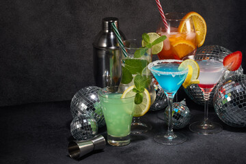 Cocktails set , disco balls (mirror balls) and bar tools on dark gray background. Nightclub. Weekend or holiday party.