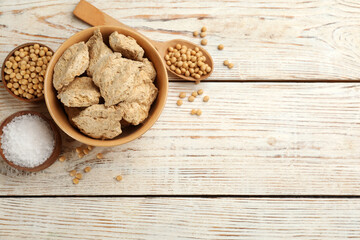 Flat lay composition with dehydrated soy meat on white wooden table. Space for text